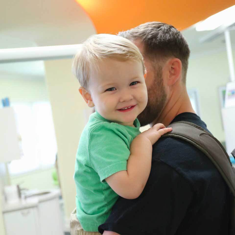 Parent holding toddler patient